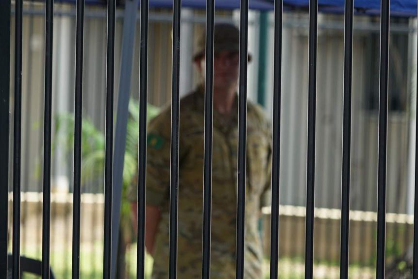 Un soldat des ADF, vêtu d'un uniforme, se tient devant le Travelodge à Darwin.