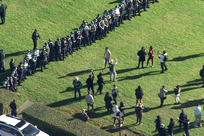 la police fait la queue dans un parc face à des manifestants