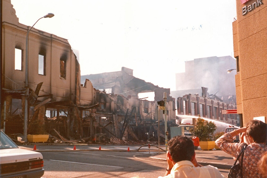 Les spectateurs regardent après qu'un incendie en 1985 a détruit le grand magasin Reids d'Ipswich, anciennement Cribb and Foote.