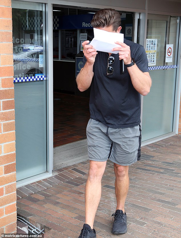 Henson, qui aurait volé un taxi sous l'influence de l'alcool, a tenu un morceau de papier pour cacher son visage alors qu'il quittait le poste de police
