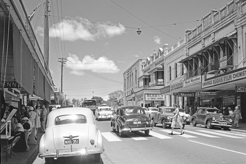 Une photo en noir et blanc d'une rue passante. 