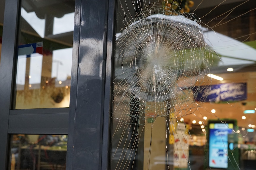 La porte vitrée d'un supermarché est brisée
